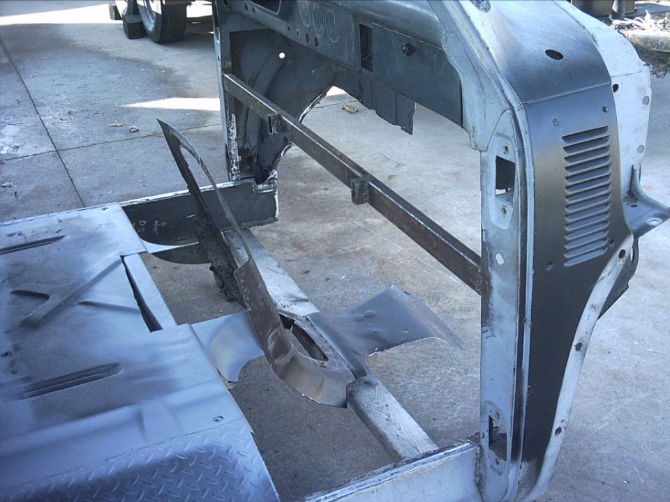 Sheet-metal cab structure under repair on a wood frame