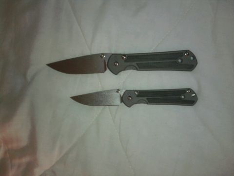 2000 Ford Crown Victoria - Two folding knives are displayed side-by-side on a white textured background.