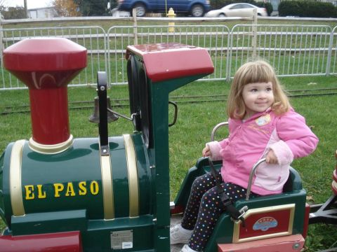 2000 Ford Crown Victoria - A child enjoys a ride on a miniature train at an amusement area.
