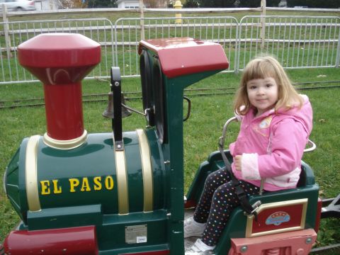 2000 Ford Crown Victoria - A young girl sits in the driver's seat of a small amusement park train.
