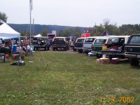 1978 Ford Bronco - Multiple 1978 Ford Bronco SUVs are parked in a grassy outdoor area, viewed from the rear.