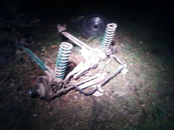 Disassembled vehicle suspension with springs and shocks on the ground