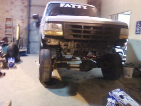 1994 Ford Bronco - Front view of a lifted truck with a prominent grille and "FATTY" decal on the windshield.