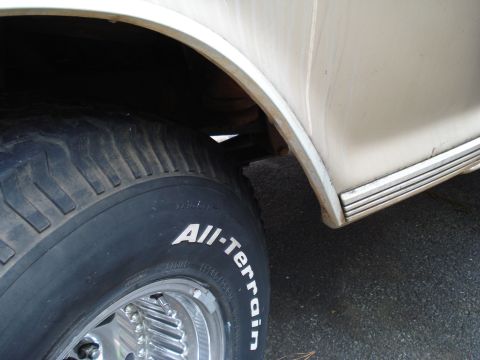 1967 Ford F-250 - Close-up view of a vehicle's tire and wheel well, showing "All-Terrain" tire branding.