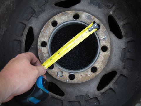 1967 Ford F-250 - A tape measure is used to measure the bolt pattern on a vehicle's wheel hub.