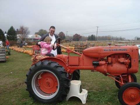 2000 Ford Crown Victoria - A man and a young girl sit on an Allis-Chalmers tractor at a pumpkin patch.