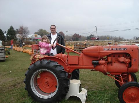 2000 Ford Crown Victoria - A man and a young girl sit on an orange Allis-Chalmers tractor at a pumpkin patch.