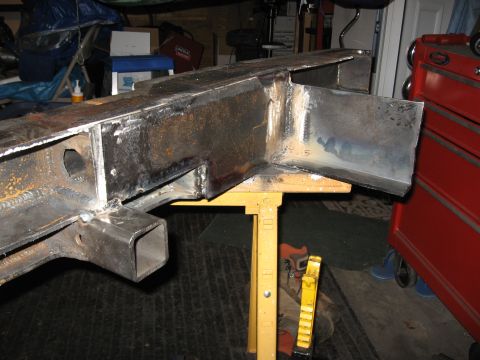 1995 Ford F-150 - A section of a welded metal frame, possibly for a vehicle, is supported by a yellow sawhorse.
