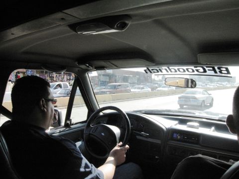 1986 Ford Bronco - The interior of a Ford Bronco is seen from the passenger seat as it drives on a highway.