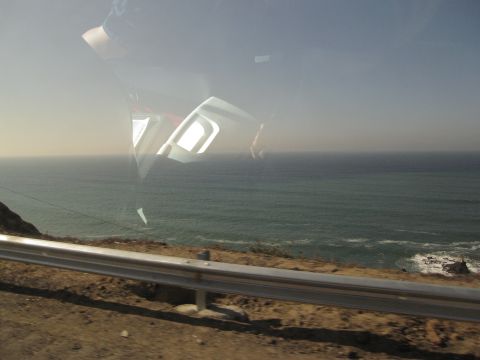 1986 Ford Bronco - The reflection on the window shows the car's interior against a backdrop of the ocean.