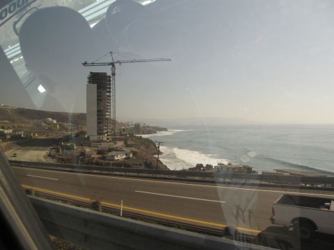 1986 Ford Bronco - View of a construction site by the ocean, with a highway in the foreground and a white pickup truck.