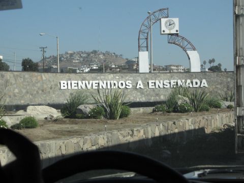 1986 Ford Bronco - A sign welcomes visitors to Ensenada, Mexico, with a large clock archway overhead.