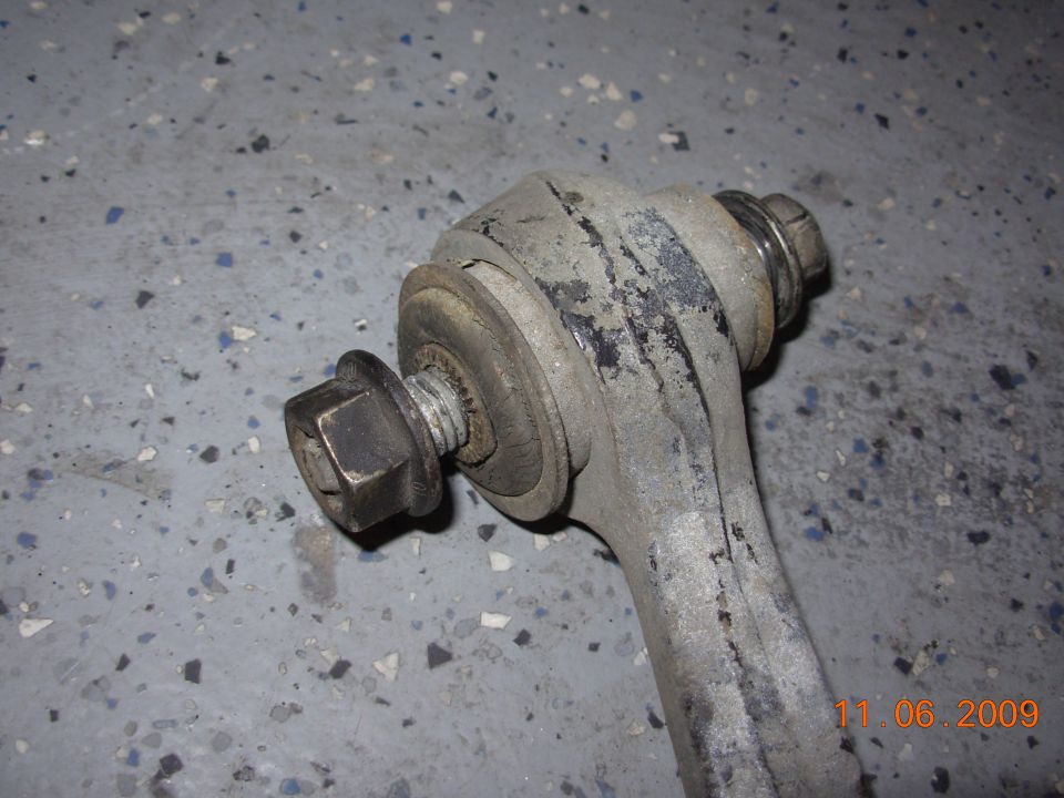 close-up of a car's suspension control arm and bolt