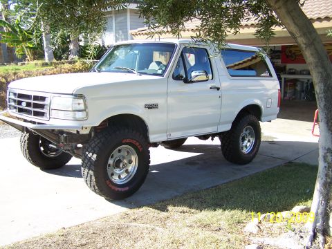 1995 Ford Bronco - This white Ford Bronco has a custom front bumper and off-road tires.