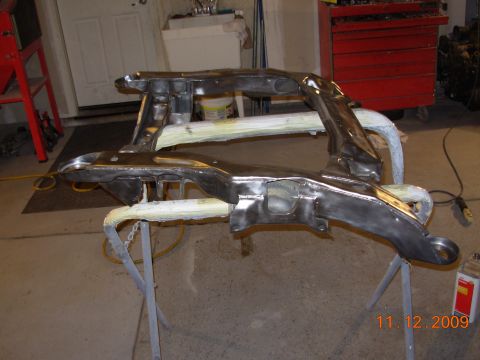 1991 Ford Taurus - Car subframe assembly on sawhorses, possibly being prepped for painting or coating.