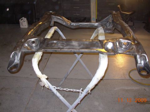 1991 Ford Taurus - A car's subframe is shown on a stand, possibly undergoing restoration or preparation for painting.