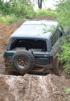 2002 Ford F-350 - This SUV appears to be stuck in a muddy off-road trail, with its rear tire mounted externally.