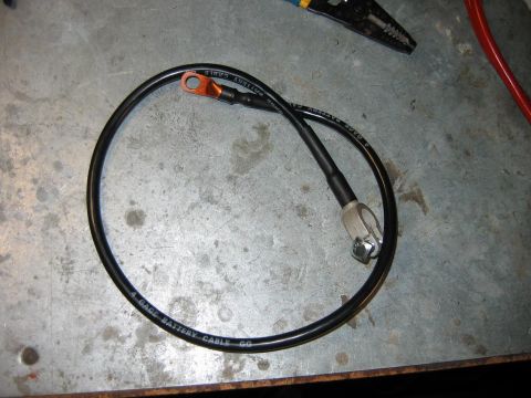 1992 Ford Bronco - A 4 gauge battery cable with copper terminal and bolt is shown on a workbench.