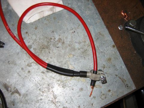1992 Ford Bronco - Close-up of a red battery cable with a terminal connector and black heat shrink tubing.