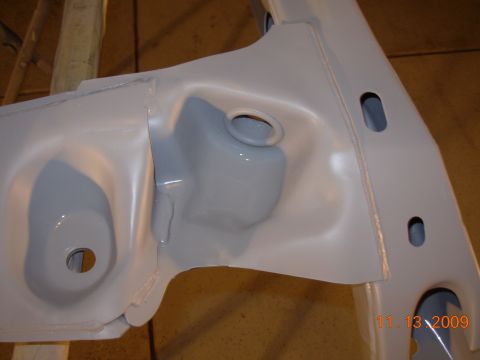 1991 Ford Taurus - A close-up view shows a painted vehicle frame component with various holes and mounting points.