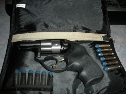 1996 Ford Bronco - A black revolver with a silver cylinder sits next to ammunition in a black case.