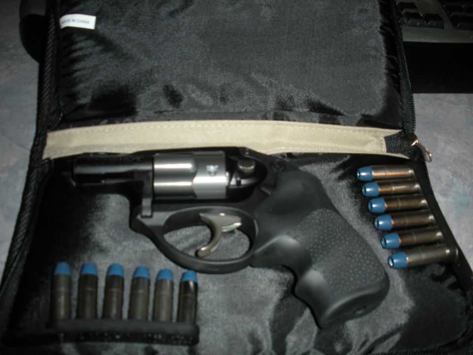 Revolver with blue-tipped bullets in a black case