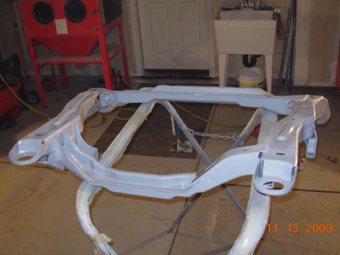 1991 Ford Taurus - A front subframe, likely undergoing restoration or modification, is shown on a stand with a sandblaster in the background.