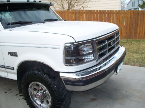 1992 Ford F-250 - Close-up of a white Ford F-250 truck's front end, showing the grille and headlights.