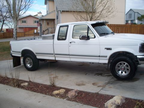 1992 Ford F-250 - Side view of a white 1992 Ford F-250 truck with a crew cab and long bed, parked in a driveway.