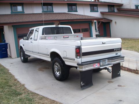 1992 Ford F-250 - Rear view of a white 1992 Ford F-250 pickup truck with mud flaps and a toolbox.