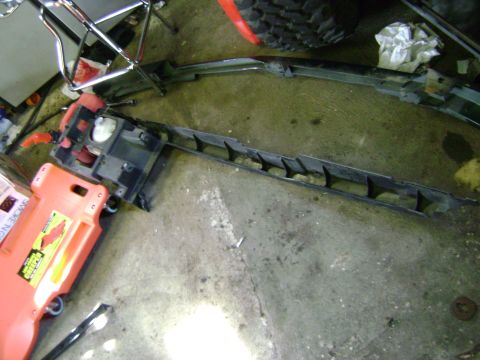 1994 Ford Bronco - Car part resting on an orange creeper in a garage setting.