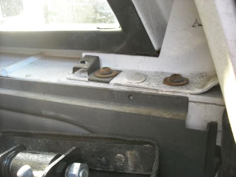1994 Ford Bronco - Close-up of rusted mounting hardware and brackets inside a vehicle.