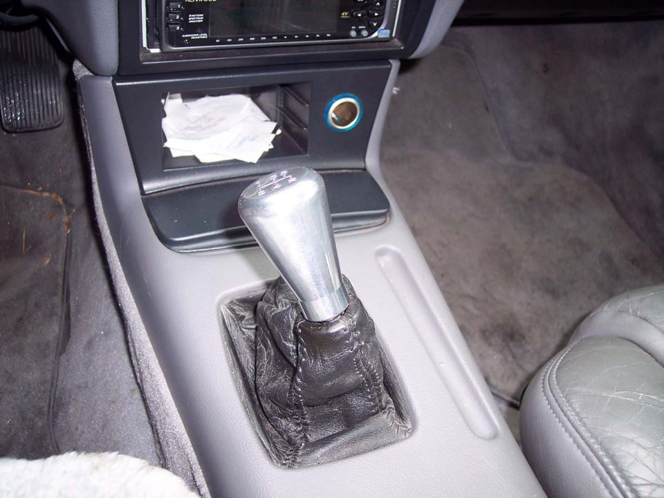 Gear shifter and center console with a Kenwood stereo above. A Supermotors logo is visible in the lower right