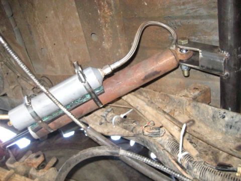 1989 Ford Bronco - Close-up view of a vehicle's undercarriage, focusing on a shock absorber and its connected components.