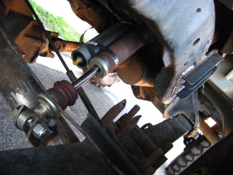 1989 Ford Bronco - Close-up of a steering stabilizer shock absorber installation on a vehicle's frame.