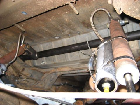 1989 Ford Bronco - The underside of a vehicle reveals its exhaust system and suspension components, with visible signs of wear and tear.
