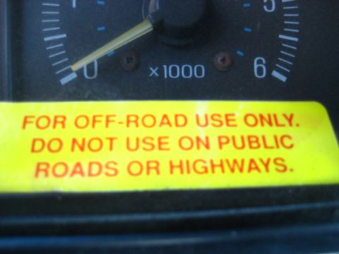 1989 Ford Bronco - A yellow sticker with red text reading "FOR OFF-ROAD USE ONLY. DO NOT USE ON PUBLIC ROADS OR HIGHWAYS." is affixed to a vehicle's dashboard…