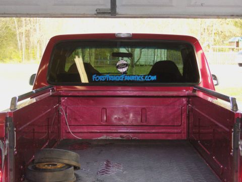 2007 Ford Mustang - Rear view of a red pickup truck, a "FORDTRUCKFANATICS.COM" sticker on the back window.