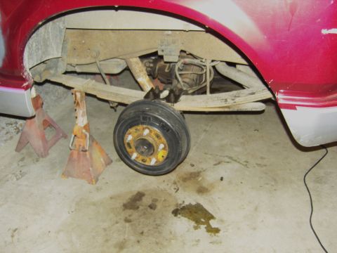 2007 Ford Mustang - The rear suspension and axle assembly of a vehicle are visible, supported by jack stands.