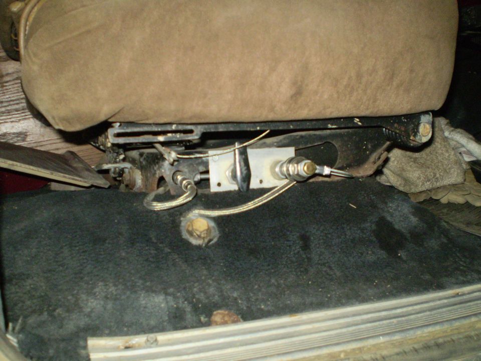 Close-up of a vehicle seat's underside, showing the adjustment mechanism and some wiring