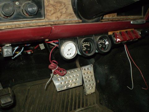 1986 Ford Bronco - Aftermarket gauges and pedals are installed on the dashboard of this vehicle.