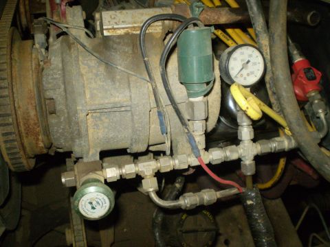 1986 Ford Bronco - This image shows a close-up of an engine component with various fittings, wires, and two pressure gauges.