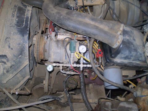 1986 Ford Bronco - Close-up view of an engine bay, showing various gauges, hoses, and mechanical components.