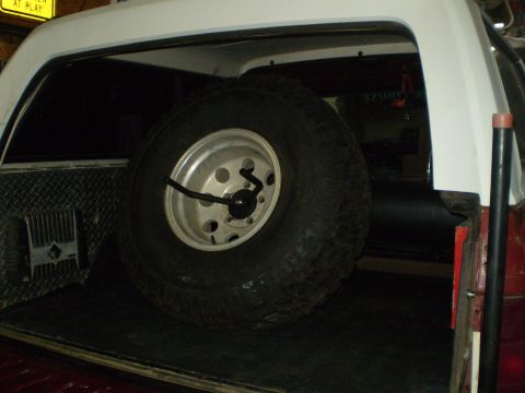 1986 Ford Bronco - Spare tire secured in the rear cargo area of the vehicle.