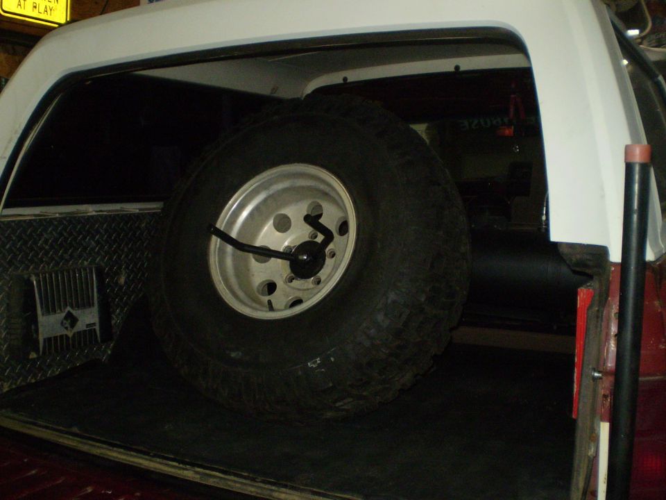 Spare tire mounted in the cargo area of a vehicle