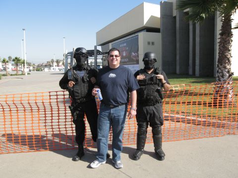 1986 Ford Bronco - A man poses for a photo with two individuals in tactical gear outside a building.
