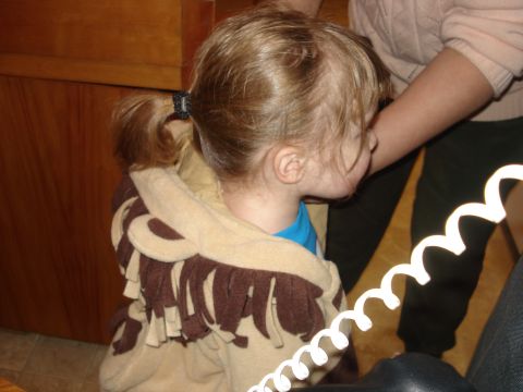 2000 Ford Crown Victoria - A child dressed in a lion costume is seen from the side, with a coiled white cord in the foreground.