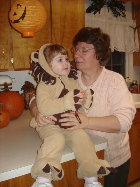 2000 Ford Crown Victoria - A woman holds a child in a lion costume, with Halloween decorations visible.
