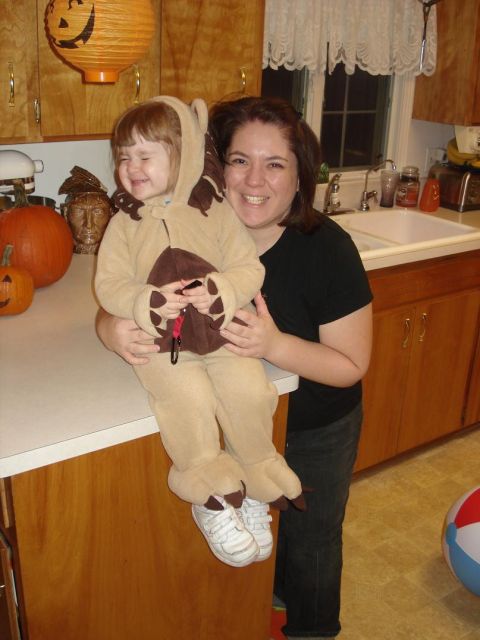 2000 Ford Crown Victoria - A child dressed as a bear sits on a kitchen counter, held by an adult, with Halloween decorations in the background.