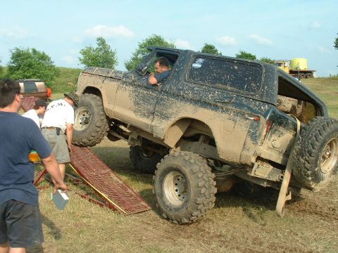 2002 Ford F-350 - This heavily modified SUV, likely from the late 1970s, is being maneuvered on a ramp with assistance.